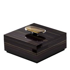 a black box with a wooden lid and a gold plate on the top, sitting on a white surface