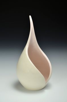 a white and pink vase sitting on top of a table