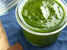 a jar filled with green liquid sitting on top of a blue cloth