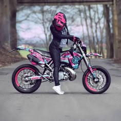 a person on a pink and black dirt bike