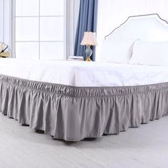 a white bed with a green ruffled skirt