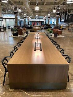 an empty conference room with long tables and chairs in front of the desks,