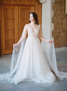 a woman in a white wedding dress is standing on the floor with her arms outstretched