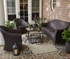 a living room with wicker furniture and potted plants on the front porch area