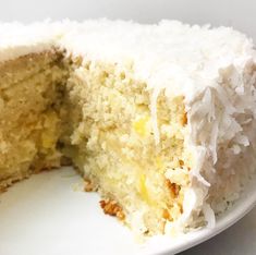 a piece of cake with white frosting and coconut on the inside is cut in half