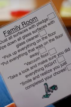 a person holding up a family room sign in front of their face with the words family room written on it