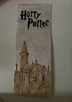 a piece of paper with the words harry potter on it and a castle in the background