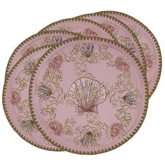 three pink plates with seashells and flowers on the rim, each decorated with gold trim