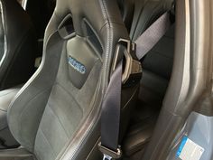 the interior of a car with two seats facing each other and one has a seat belt attached to it