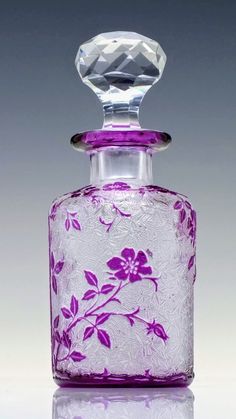 a purple and white glass bottle sitting on top of a table