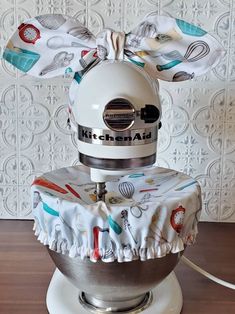 a kitchen aid mixer with a bow on it's head sitting on top of a table