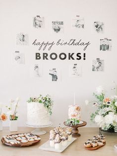 a table topped with cakes and cupcakes on top of a wooden table next to pictures