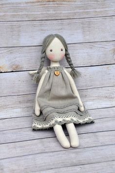 a little doll sitting on top of a wooden floor