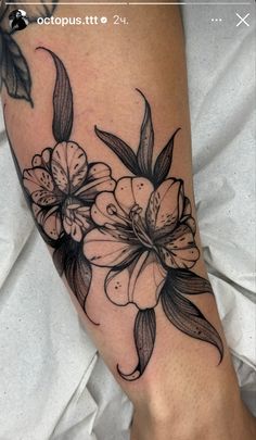 a black and white flower tattoo on the leg