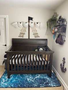 a baby crib in the corner of a room with blue rugs and decorations on the wall