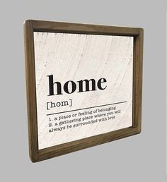 a wooden framed sign with the words home and definition printed on it in black ink