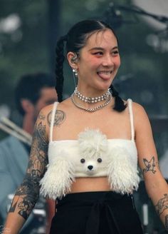 a woman in a crop top with a dog on her chest