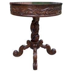 an ornate wooden table with carved carvings on the top and legs, against a white background