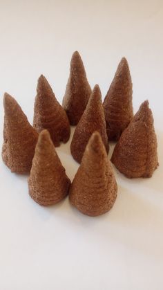 small brown felted cones on a white surface