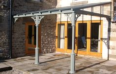 an outdoor patio with a pergolated area and wooden doors