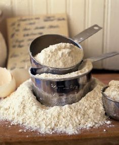 three bowls with flour in them sitting on a table