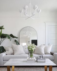 a living room filled with furniture and a large mirror on the wall above it's coffee table