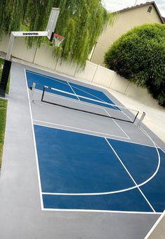 an outdoor basketball court is painted blue