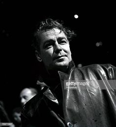 a black and white photo of a man in a leather jacket looking off to the side