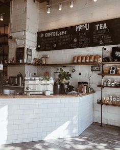 the inside of a coffee shop with menus on the wall and shelves above it