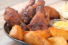 a plate full of fried chicken wings with mustard and ketchup on the side