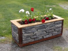 a stone planter with flowers growing out of it