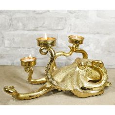 a gold octopus candle holder with three candles