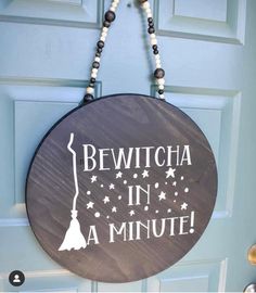 a sign that says bewitcha in a minute hanging on the front door