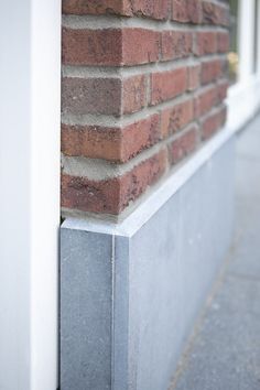 the corner of a red brick building with white trim