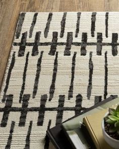 a potted plant sitting on top of a wooden table next to a white rug