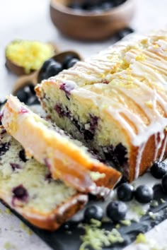 a loaf of blueberry pound cake with icing and fresh blueberries on the side