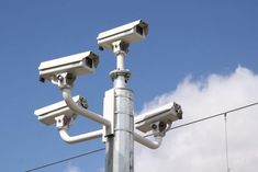 three cameras on top of a metal pole