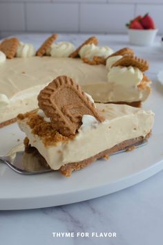 a white plate topped with a cake covered in frosting and graham cracker crust