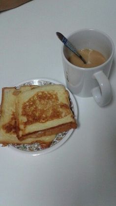 two pieces of toast on a plate next to a cup of coffee