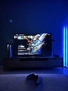 a flat screen tv sitting on top of a wooden stand in front of a blue wall