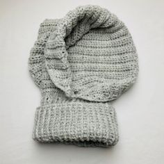 a knitted hat and mitten on a white surface