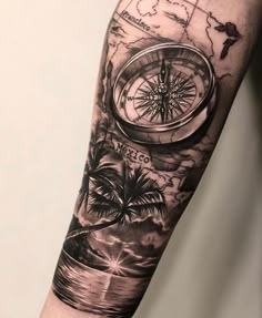 a man's arm with a compass tattoo on it