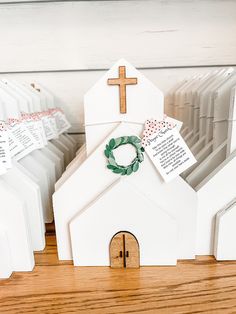 a small white church with a wreath on the front and two cards attached to it