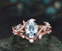 a ring with an aqua blue stone surrounded by white diamonds on top of a rock