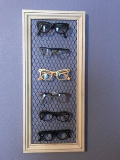 a wall mounted display case with several pairs of glasses