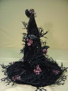 a black hat with flowers and branches on it