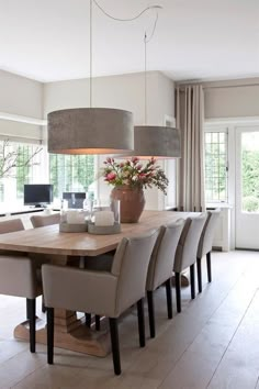 a dining room table surrounded by chairs and lamps