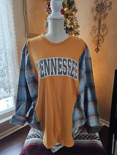 an orange shirt with the word tennessee on it is sitting on a mannequin