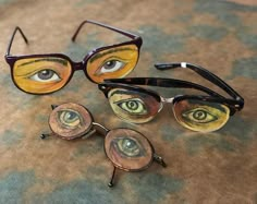 three pairs of eyeglasses with different designs on them sitting next to each other