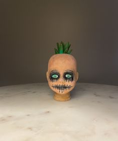 a fake skull with green eyes and a pineapple on its head